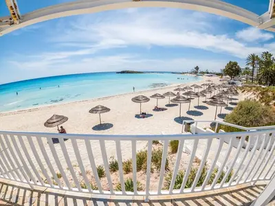 a view of a beach with umbrellas and the ocean at NISSI GOLDEN SANDS SEA VIEW 2 BEDROOM Apartment in Ayia Napa