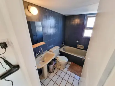 a bathroom with a tub and a toilet and a sink at City View Rooms in Larnaka