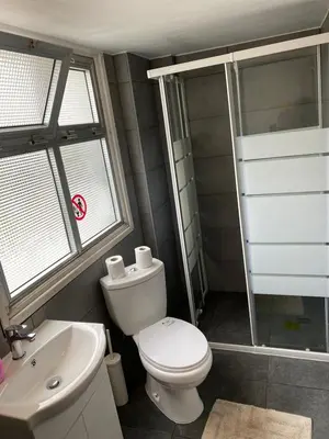 a bathroom with a toilet and a sink and a shower at City View Rooms in Larnaka