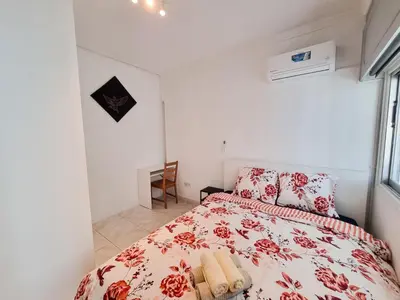 a bedroom with a bed with a red and white comforter at City View Rooms in Larnaka