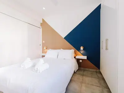 a bedroom with a large white bed with towels on it at Shelter next to the beach in Larnaka