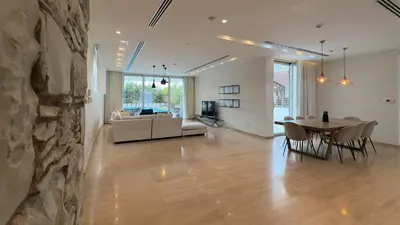 a living room and dining room with a stone wall at Vivo Mare Beachfront Villas - Seashell in Ayia Napa