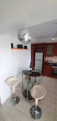 a kitchen with a glass table and two stools at Vasilas Holiday Apartment #2 in Larnaka