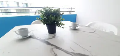 a table with two cups and a potted plant on it at Vasilas Holiday Apartment #2 in Larnaka