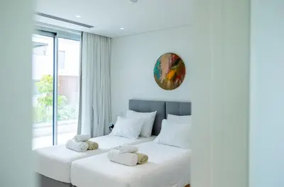 two white beds in a room with a window at Vivo Mare Beachfront Villas - Vista in Ayia Napa