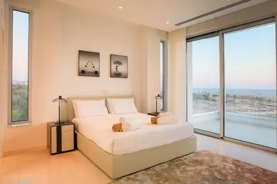 a bedroom with a white bed and large windows at Sea Pearl Beachfront Villas - Breeze in Ayia Napa