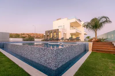 a swimming pool in front of a house at Sea Pearl Beachfront Villas - Breeze in Ayia Napa