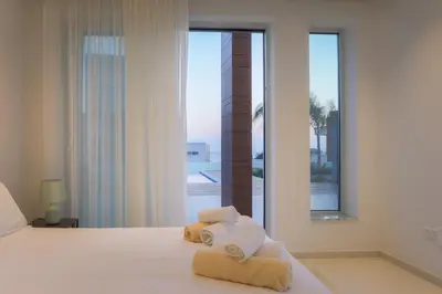 a bedroom with towels on a bed with a window at Sea Pearl Beachfront Villas - Anemone in Ayia Napa