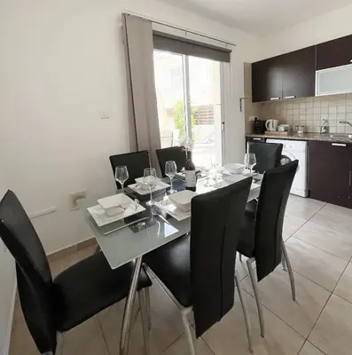 a dining room with a table and black chairs at Nissi Beach Golden Villas in Ayia Napa
