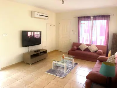 a living room with a couch and a tv at Nissi Beach Golden Villas in Ayia Napa