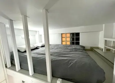 a bed in a white room with a window at Central Ground Floor Apartment in Nicosia