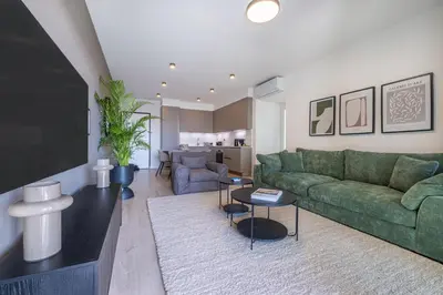 a living room with a green couch and a tv at Sunset Gardens in Limassol