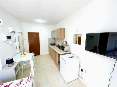 a small kitchen with a table and a tv at Central Comfort Studio in Larnaka