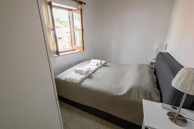 a small bedroom with a bed and a window at Omodos vintage houses in Omodos