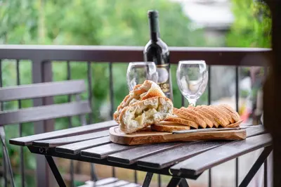 a wooden table with a plate of bread and wine glasses at Omodos vintage houses in Omodos