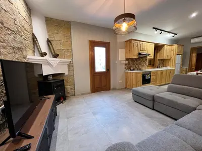 a living room with a couch and a fireplace at Eftis - Renovated Traditional House in Omodos