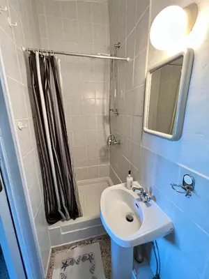 a bathroom with a sink and a shower with a mirror at Cottage Apartment Othellos in Kalavasos