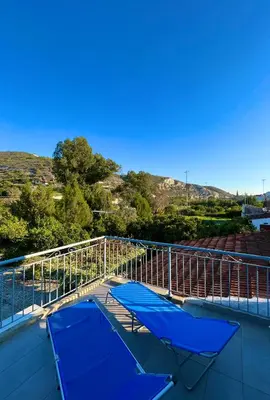 a balcony with two blue chairs and a railing at Cottage Apartment Othellos in Kalavasos