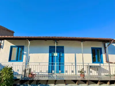 a house with blue doors and a balcony at Cottage Apartment Othellos in Kalavasos