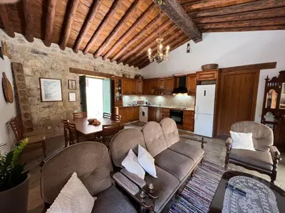 a living room with a couch and chairs and a kitchen at King's house in Lofou