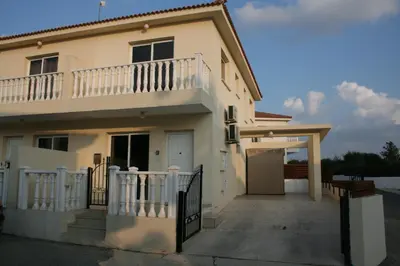 a white house with a balcony and a driveway at Nissi Villa in Ayia Napa