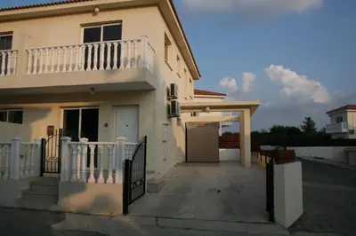 a white house with a porch and a driveway at Nissi Villa in Ayia Napa