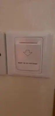 a white lightswitch on a wall with an arrow on it at STEFARIS PROPERTIES 'sioukris court' in Larnaka