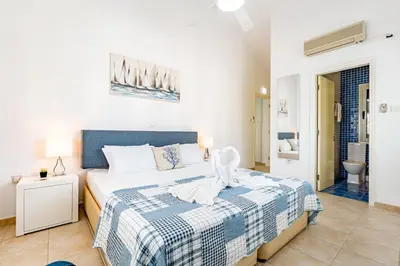 a bedroom with a bed with a blue and white blanket at Villa Elliana by Ezoria Villas in Protaras