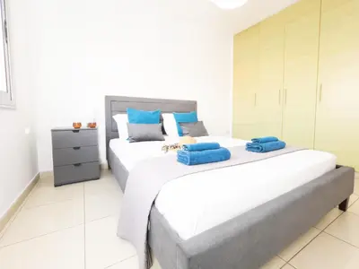 two beds in a room with white and blue at Pandora Holiday Apartment Ayia Napa in Ayia Napa