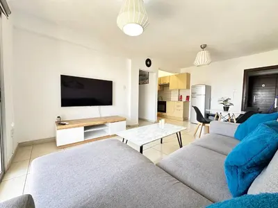 a living room with a couch and a flat screen tv at Pandora Holiday Apartment Ayia Napa in Ayia Napa