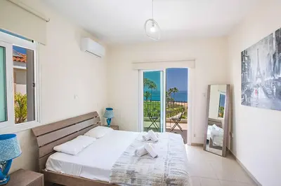 a bedroom with a bed with a view of the ocean at Villa Mesogeios ME16 in Protaras