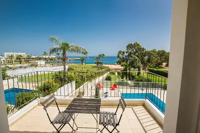 a balcony with a table and chairs and the ocean at Villa Mesogeios ME16 in Protaras