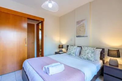 a bedroom with a large bed with two towels on it at Freya 1-Bedroom Apartment in Larnaca in Larnaka