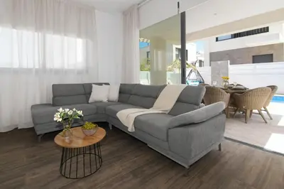 a living room with a gray couch and a table at Villa Talia in Protaras