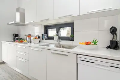 a white kitchen with a sink and a bowl of fruit at Villa Talia in Protaras