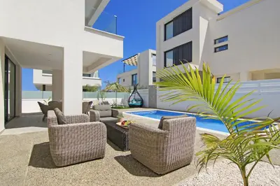 a patio with chairs and a swimming pool in a house at Villa Talia in Protaras