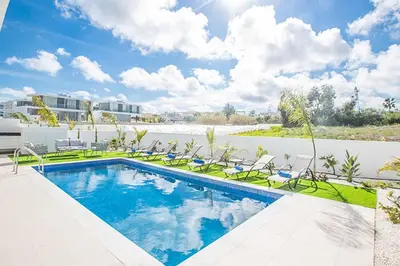 a swimming pool with lawn chairs and a swimming pool at Olivine Pearl OL21 in Protaras