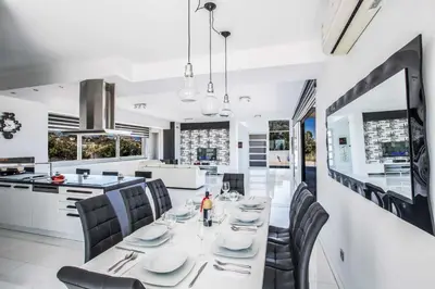 a kitchen and dining room with a table and chairs at Villa Pallas KO1 in Protaras