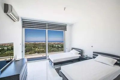a bedroom with two beds and a large window at Villa Pallas KO1 in Protaras