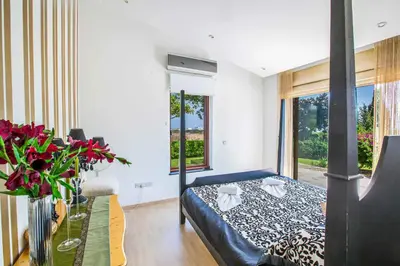 a bedroom with a bed and a table with flowers at Villa Nyx in Protaras