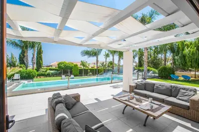 a patio with a couch and a table and a pool at Villa Nyx in Protaras