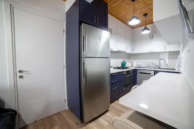 a kitchen with a stainless steel refrigerator and blue cabinets at Archontiko Adamou in Kyperounda