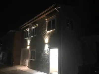 a building with lights on the side of it at night at Archontiko Adamou in Kyperounda