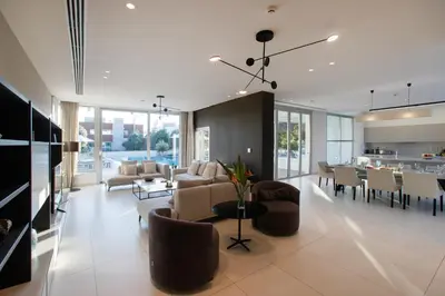 a living room with couches and chairs and a kitchen at Vivo Mare Beachfront Villas - Emerald in Ayia Napa
