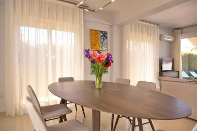 a dining room table with a vase of flowers on it at Velomar Villa in Paralimni