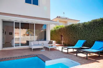 a patio with two blue chairs and a pool at Velomar Villa in Paralimni