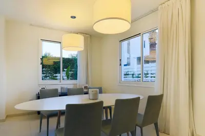 a dining room with a white table and chairs at Pernera Gardens Villa in Protaras