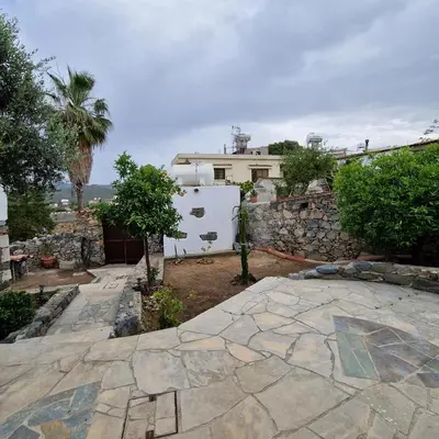 a backyard with a stone wall and a white refrigerator at THE ROCK HOUSE - Beautiful countryside with mandarins oranges and olive trees,. Near Limassol at Eptagonia village. in Ephtagonia