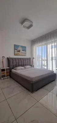 a bedroom with a large bed in a white room at Cosmos Residence in Paralimni