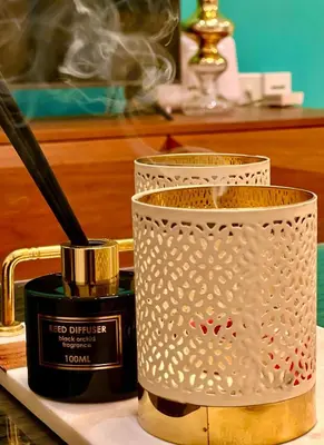 a container with a stick in it next to a candle at Cosmos Residence in Paralimni
